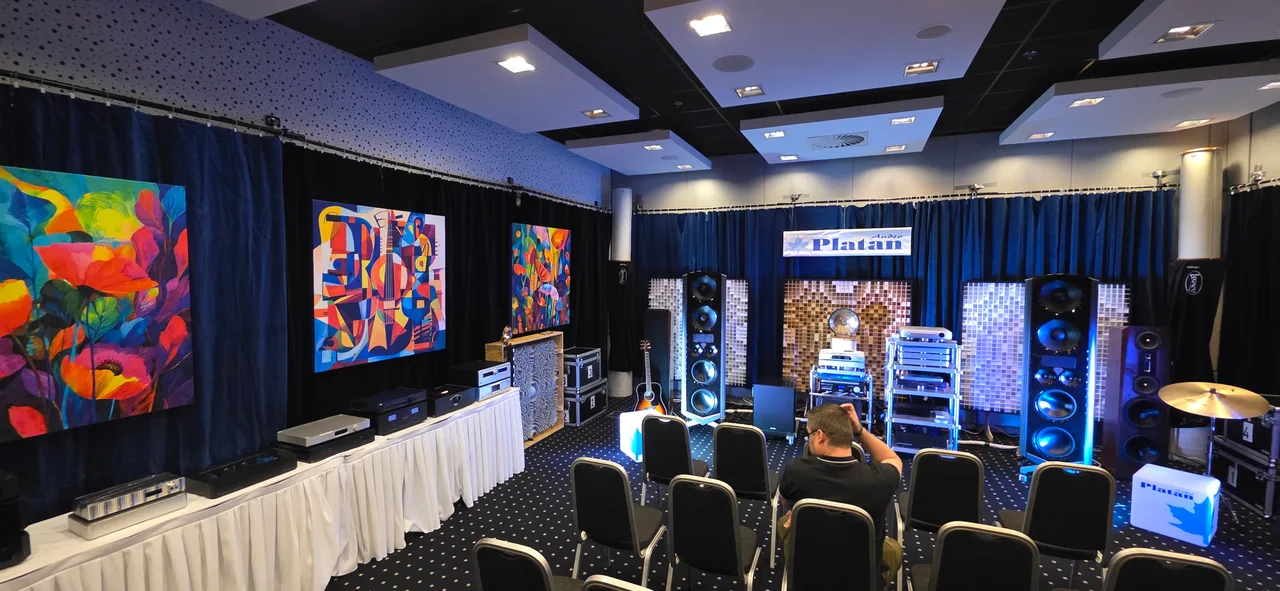 Floral and geometric canvas prints along the wall of an audio exhibition room.